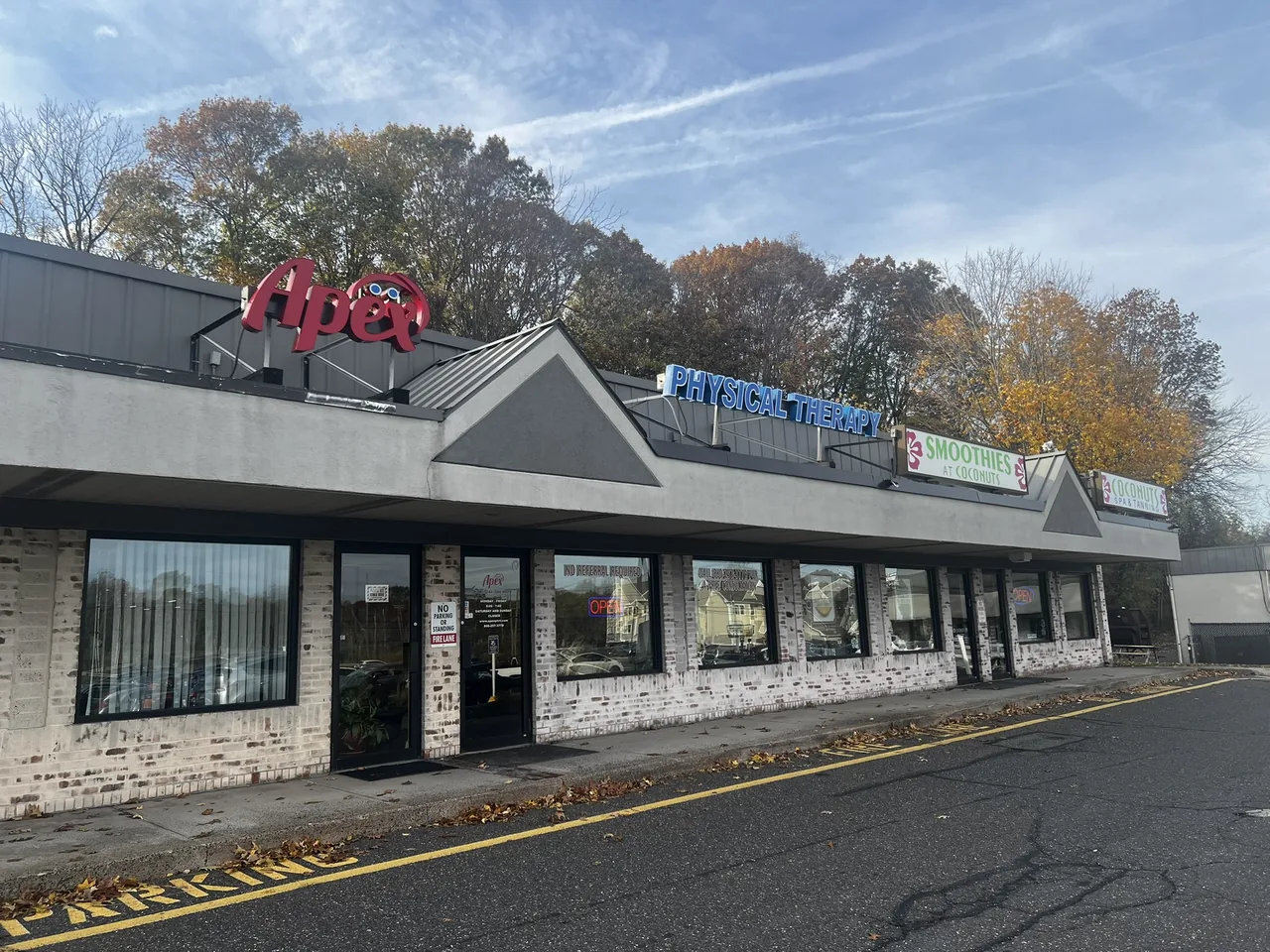The Apex Physical Therapy clinic exterior on Cromwell Avenue in Rocky Hill, Connecticut, with the Apex and Physical Therapy signs above the entrance and autumn trees behind the building.